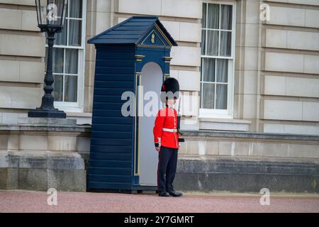A traditional British guard stands stoically in front of a historic building, showcasing iconic culture and tradition. Stock Photo