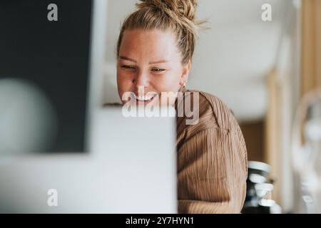 Happy female business professional working on laptop at office Stock Photo