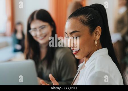 Young businesswoman discussing with female coworker at workplace Stock Photo