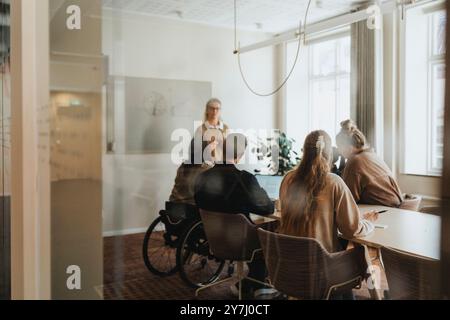 Male and female business professionals having discussion in meeting room at office Stock Photo