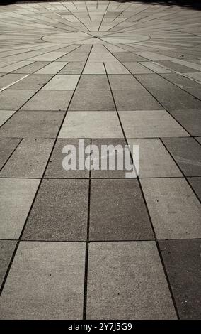 Texture of gray tsetse sidewalk in sunlight in Tallinn. Gray rectangular tiles in perspective. Background. Vertical. Stock Photo