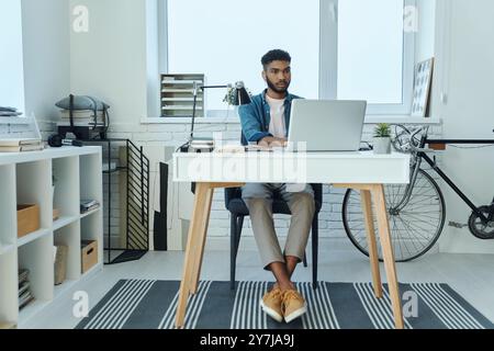 Concentrated young African man using laptop while working in office Stock Photo