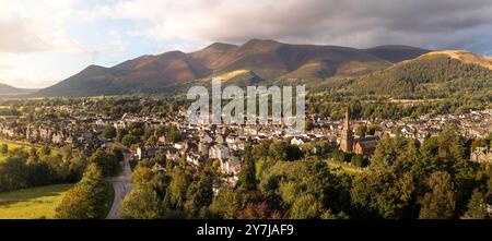 Aerial panoramic landscape of the Lake District town of Keswick on a beautiful Summer day with Bassenthwaite Lake and Skiddaw in The Northern Fells be Stock Photo