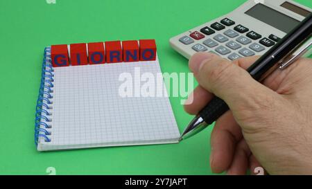 DAY single word written on wooden cubes, with green background and office stationery Stock Photo