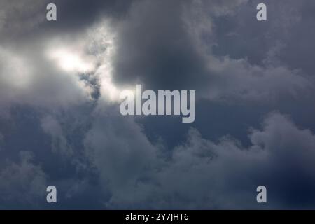 Dramatic storm clouds backlit by the sun. Stock Photo