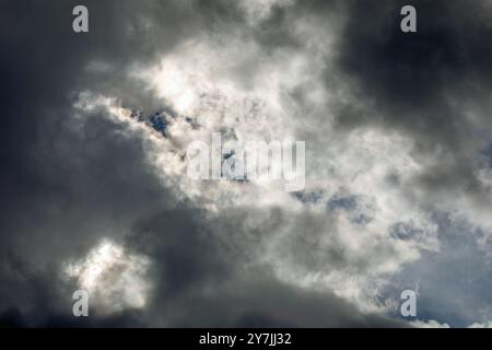 Dramatic storm clouds backlit by the sun. Stock Photo