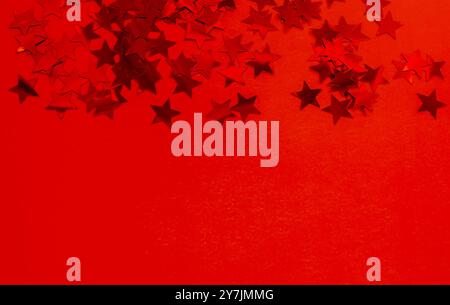 Red Star Confetti on Red background. Greeting Card for Christmas, New Year and Birthday with Copy space. Stock Photo