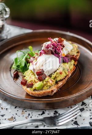 Avocado guacamole toast with poached eggs on top. Brunch food. Stock Photo