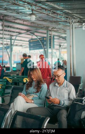 People are in an airport lounge using mobile devices for communication and leisure Stock Photo