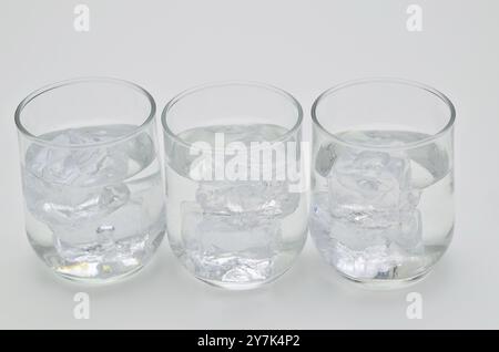 three glasses of water with ice cubes, close up, isolated on white background Stock Photo