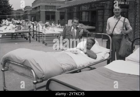 cigarettes in hospitals Man in hospital bed smoking a cigarette ca. 1936 Stock Photo