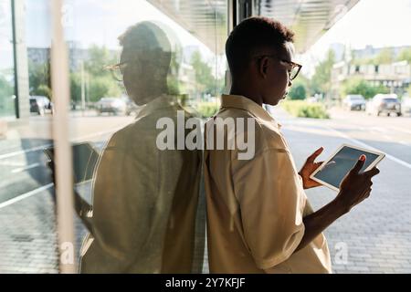 Young Black Male Manager Using Digital Tablet Outdoors Stock Photo