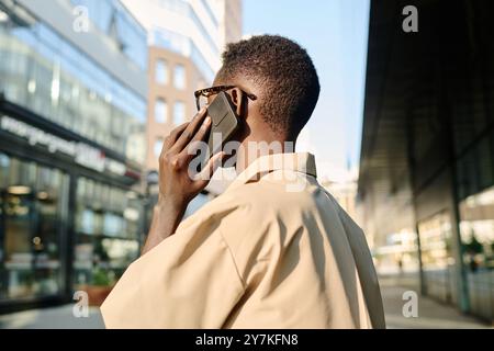 Young Black Man Talking On Phone Outdoors Stock Photo