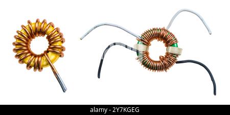 Closeup of toroidal inductor and transformer isolated on white background. Two different coils - electrical components with spiral wrapped copper wire. Stock Photo