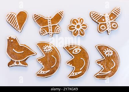 Closeup of aromatic decorated gingerbread cookies on white background. Set of cute baked moons, butterflies and sweets in bird, heart or flower shape. Stock Photo