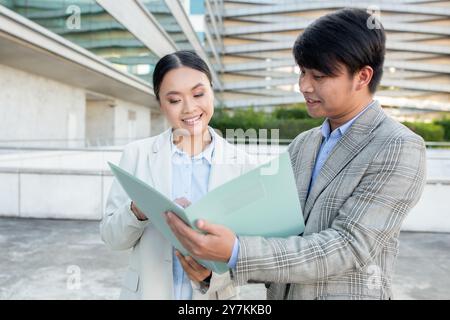 Young professionals discussing project ideas outdoors in an urban area Stock Photo