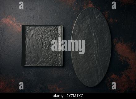Oval and square stone kitchen board on black background, top view Stock Photo