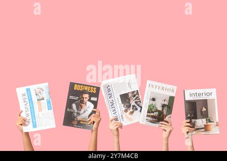 Female hands with different magazines and newspapers on pink background Stock Photo