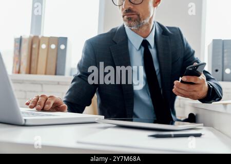 Close-up of unrecognizable mature man in formalwear using laptop while sitting in the office Stock Photo