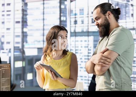 Team of data science workers conducting code review on tablet to fix bugs, identifying technical issues with artificial intelligence company software. IT staff members optimizing code using device Stock Photo