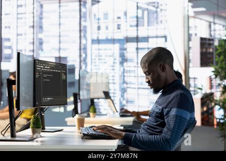 Computer technician doing software quality assurance, reading source code on computer before implementing it. IT admin inspecting coding on PC device, looking to fix potential issues Stock Photo