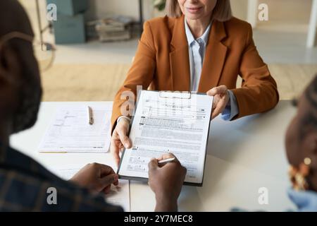 Top View at Financial Advisor Handing Form to Clients Stock Photo