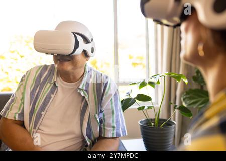 Using VR headsets, family members enjoying virtual reality experience together Stock Photo