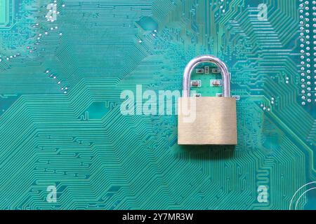 Golden master key in lock placed on a computer motherboard background, Concept of securing users and computer systems from hackers. Stock Photo
