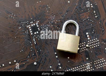 Golden master key in lock placed on a computer motherboard background, Concept of securing users and computer systems from hackers. Stock Photo