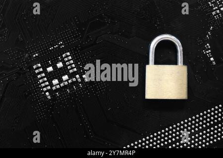 Golden master key in lock placed on a computer motherboard background, Concept of securing users and computer systems from hackers. Stock Photo