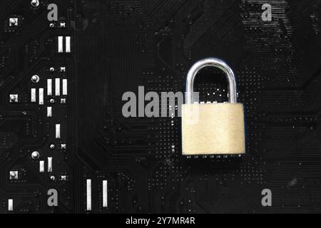 Golden master key in lock placed on a computer motherboard background, Concept of securing users and computer systems from hackers. Stock Photo