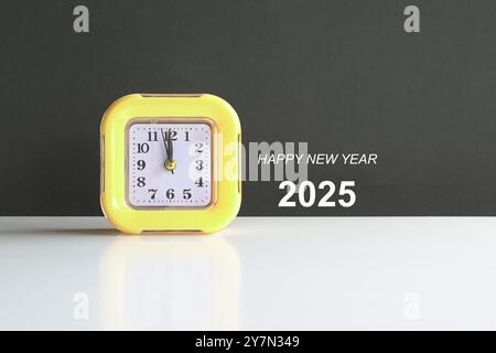 Happy New Year 2025, text  next to a yellow clock. Stock Photo