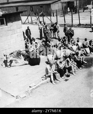 Survivors in the 'quarantine camp' section of Mauthausen after liberation. Mauthausen was a Nazi forced labour camp, part of the Mauthausen complex. At its height it had 85,000 prisoners at any one time. It was infamous for its harshness - it is estimated that of the 190,000 prisoners held there during its operations, fully half died. It was home to the Wiener Graben quarry and its feared Stairs of Death (Todessteige) where many died carrying huge loads up the 186 stone steps. Stock Photo