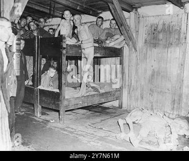 Survivors of the Mauthausen concentration camp pose inside a barracks after liberation. The bodies of dead prisoners have been piled in the open area to the right. Mauthausen was a Nazi forced labour camp, part of the Mauthausen complex. At its height it had 85,000 prisoners at any one time. It was infamous for its harshness - it is estimated that of the 190,000 prisoners held there during its operations, fully half died. It was home to the Wiener Graben quarry and its feared Stairs of Death (Todessteige) where many died carrying huge loads up the 186 stone steps. Stock Photo