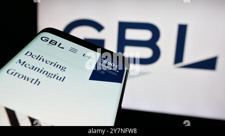 Mobile phone with webpage of company Groupe Bruxelles Lambert S.A. (GBL) on screen in front of business logo. Focus on top-left of phone display. Stock Photo