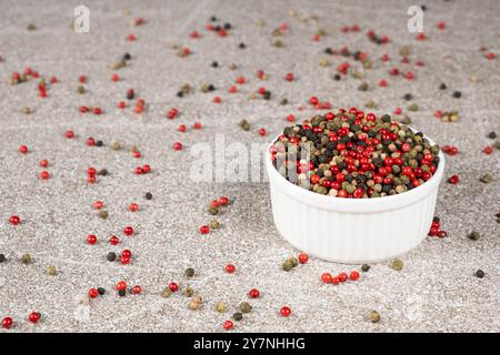 Multicolored peppercorns on a stone gray background Stock Photo