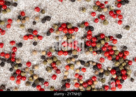 Multicolored peppercorns on a stone gray background Stock Photo