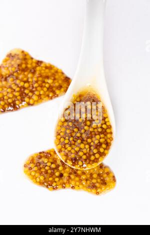 Traditional French Dijon mustard in a spoon on a white background. Stock Photo