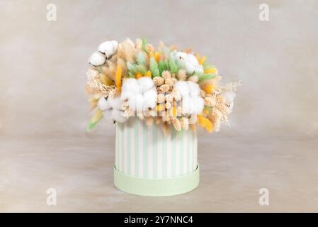 beautiful bouquet of dried flowers in cardboard basket on light background. Space for text Stock Photo