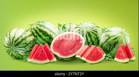 Large group of round striped watermelon and watermelon slices isolated on green background. Stock Photo