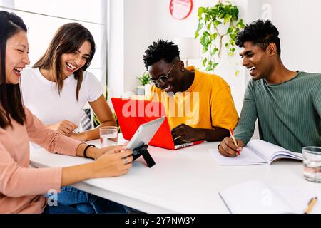 Young group of happy student friends working together with laptop at home Stock Photo