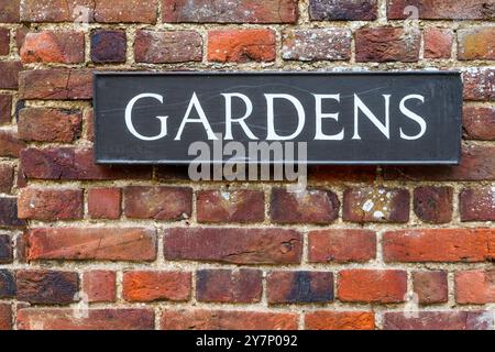 Gardens sign on an old brick wall. Stock Photo