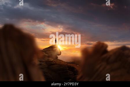 Leadership And Goals. A man standing on top of a mountain at sunset. Conceptual photo composite. Stock Photo