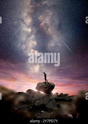 A man standing on A rock as the milky way galaxy rises into the night sky at dusk. Photo composite Stock Photo