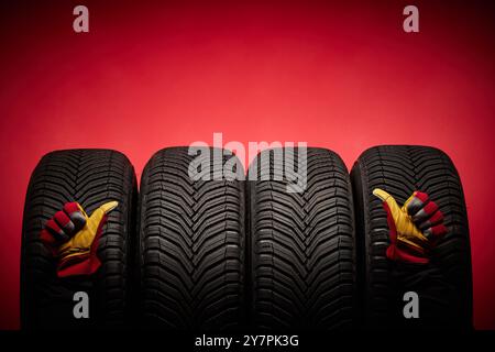 Car tires service and hand with thumb up of mechanic or driver on red background, formula racing, speed drive and wheels concept. Stock Photo