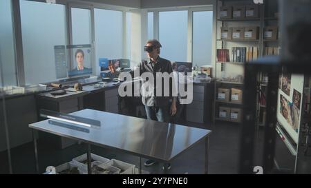 Advanced archaeological lab: 3D graphics of virtual display with AI assistant, animation of ancient dinosaur species. Archaeologist in VR headset conducts scientific research using augmented reality. Stock Photo
