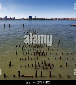 A forest of pilings remain at Pier 56, part of the Chelsea Piers complex that once served Cunard-White Star Lines, now serve Hudson River’s gulls. Stock Photo