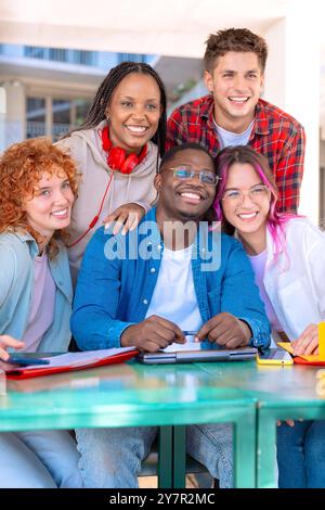 Multiethnic group of students sitting in a library and studying ...