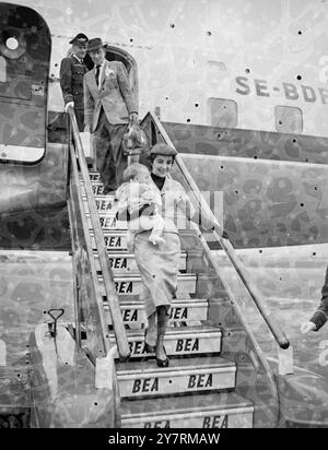 MICHAEL WILDING & ELIZABETH TAYLOR ARRIVE IN LONDON WITH MICHAEL JUNIOR 10.10.53. Film actress Elizabeth Taylor, who suffered from a nervous breakdown recently, flew into London today with her film star husband Michael Wilding and their young son Michael Junior. They arrived at London Airport aboard the same aircraft as Queen Louise of Sweden. I.N.P. photo shows: With Michael Junior slung across her shoulder, Elizabeth Taylor walks down the steps of the plane followed by husband Michael Wilding. Picture by Joe Waldorf.  INTERNATIONAL NEWS PHOTOS. Stock Photo