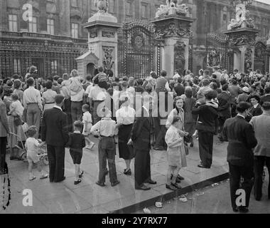 BANK HOLIDAY CORONATION CROWD THRONG THE PALACE AND THE MALL ENJOYING THE HOT WEATHER.  24.5.53.  The custom used to be that Londoners and others rushed  to get out of the City on Bank Holiday, now it is  reversed, they are thronging in their thousands to  various points along the route that the Coronation  procession will take. The sun was blazing, decorations  were gay and colourful and the crowd entered into the  spirit of the thing and enjoyed the splendour that is London today.  PHOTO SHOWS: Crowds gather outside Buckingham Palace  to watch for any little movement from either  within or o Stock Photo